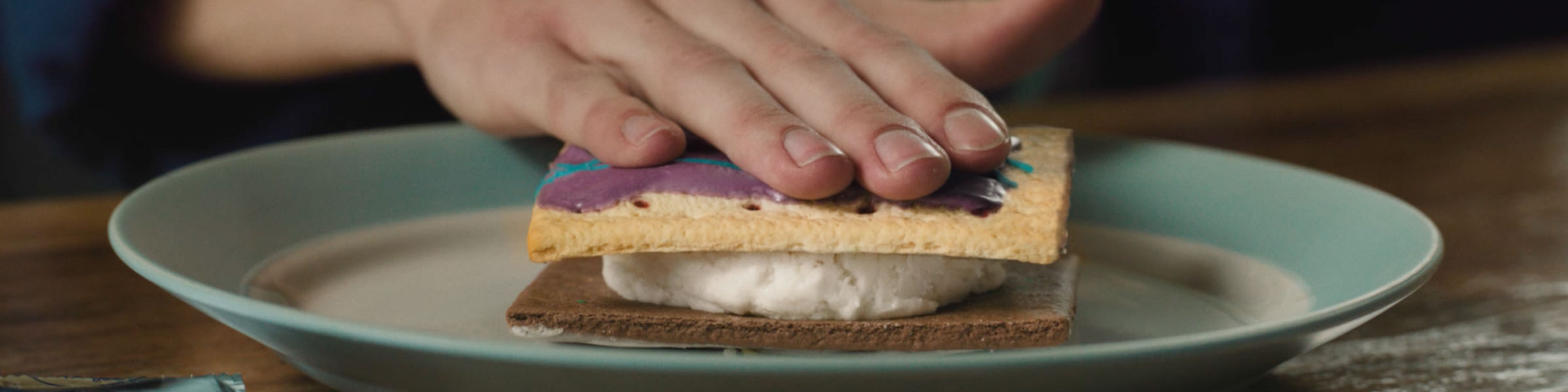 Pop-Tarts characters swinging on trapeze swings toward a large marshmallow ball